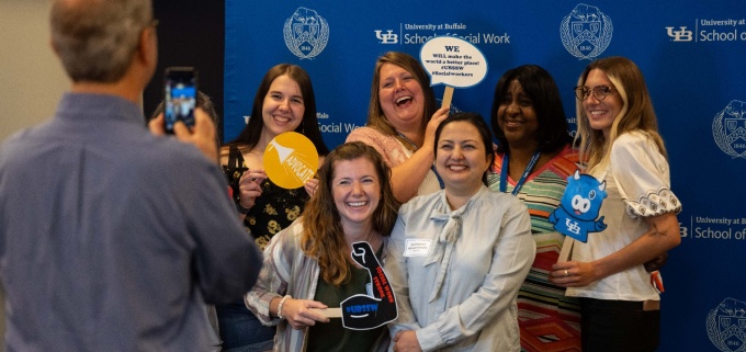 A group of social work students holding signs that display messages like "I will make a difference" and "I am a change agent".